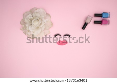 Eye lashes woman's accessories and nail polish on pink background 