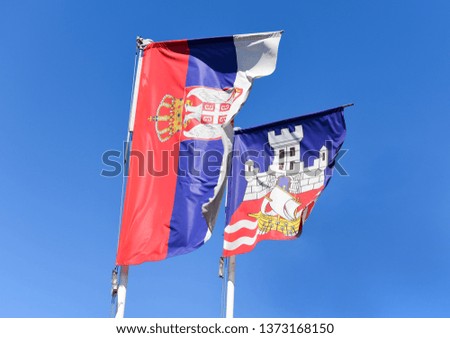 Serbian flag and flag of Belgrade city waving on the wind