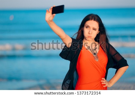 Female Tourist Taking Selfies at Sunset by the Sea. Woman taking pictures of herself at the beach in summer holiday