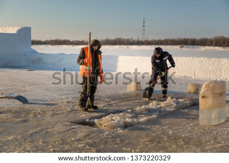 Workers clean ice hole cut in the river of ice