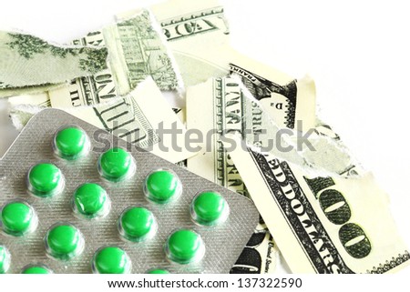 Green pills with dollar on white background