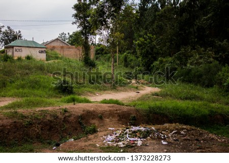 Migadde, Bombo Road, Kampala Kawempe Matugga Uganda landscape scenery at a primary school. The scenery contains a boys and girls toilet bathroom and a pile of trash. A combination of the found