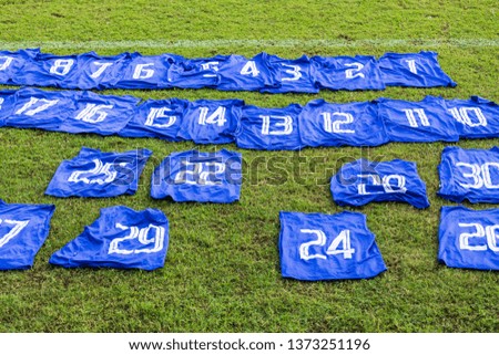 Blue shirts have a number that is placed on the football field when practicing