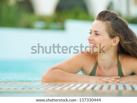 Happy young woman in pool looking on copy space