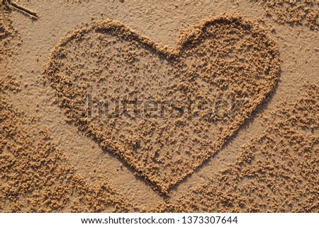 Heart symbol made on sand at sea shore