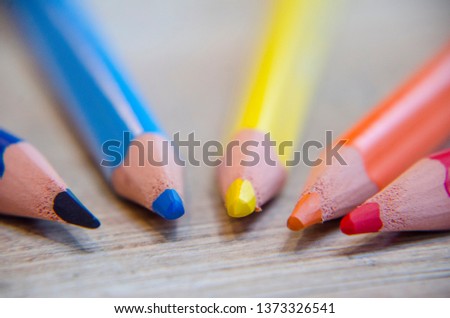 macro photo of wooden color pencils or pen in detail with bokeh or faded background, many different colors are used pencils are at the bottom of the picture, usable for birthday cards, website