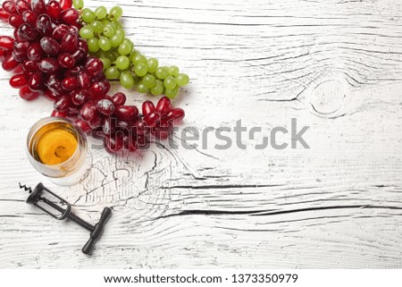 Cheese, honey, grape, nuts and wineglass on white wooden board. Top view with copy space.
