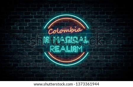 A red and blue neon light sign that reads:
Colombia is magical realism