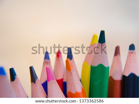 macro photo of wooden color pencils or pen in detail with bokeh or faded background, many different colors are used pencils are at the bottom of the picture, usable for birthday cards, website