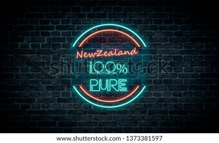 A red and blue neon light sign that reads:
New Zealand 100% Pure