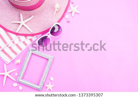 Beach accessories picture frame, sunglasses, starfish, beach hat and sea shell on pink background for summer holiday and vacation concept.