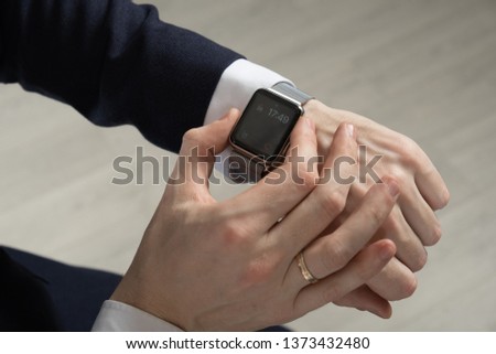 men's hands in a suit indicate a smart watch