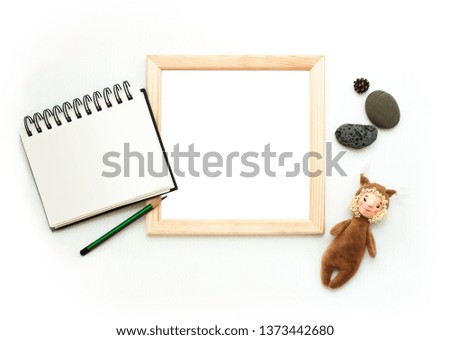 Flat lay mock up, top view, wooden frame, toy squirrel, pencil, note pad, stones. Interior layout, square poster mockup, wood frame, white background. Retro template poster, picture, art painting.