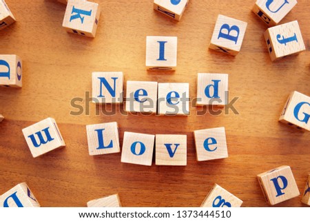 I need love. Conceptual image with the text made from wooden cubes on a desk