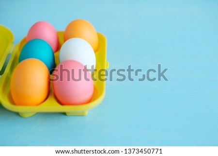 Easter painted eggs on a blue wooden table in tray. soft focus. Happy Easter