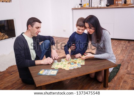 Happy family playing together on the table at home. Son with his mother and dad