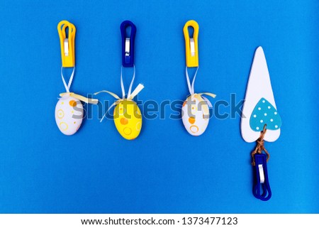 Easter eggs hang on clothespins. Blue background. happy Easter. Easter.
