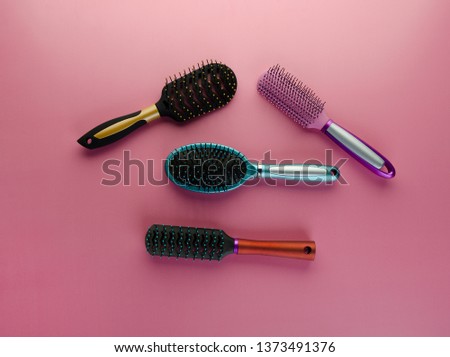 Various colored brushs and combs for hair on pink background. Set of brush and hairbrush 
