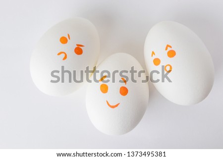 White eggs with smilies painted with markers. Emotions of surprise, joy and anger. Funny Emoji on a white background. Could be used as a background. Easter.