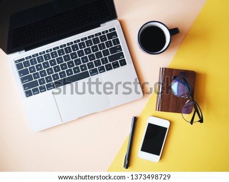 Top view laptop,smart phone and coffee cup on yellow background.
