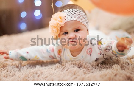 Cute little girl with ballons sittimg on bed. Happy birthday, five mouth old baby - Image