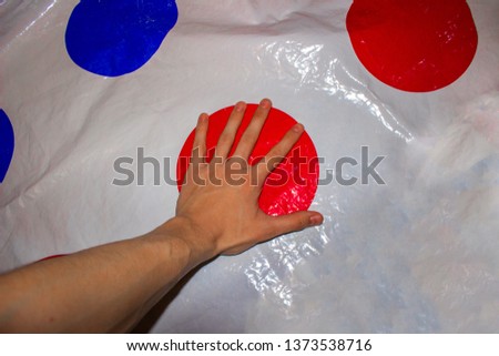 
Twister. A game. Hand lying on the game.