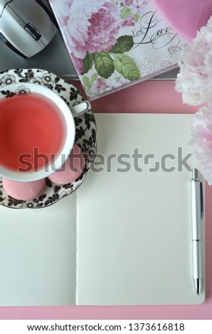 Elegant styled feminine desktop - relaxation, reading, creative writing, learning and journaling concept - with pink peonies, fruit tea and stylish stationery