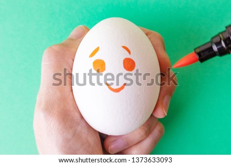 White egg with smilie painted with markers. Emotions of joy, happy. Funny Emoji on a white background. Could be used as a background. Easter. Place for text.