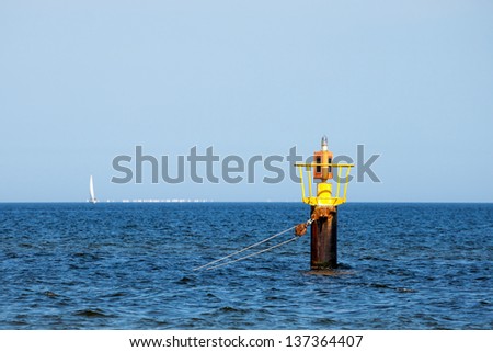 Yellow mooring buoy in a calm bay in the Baltic sea.