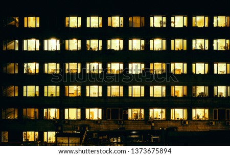 Windows of night house with yellow warm light inside Royalty-Free Stock Photo #1373675894