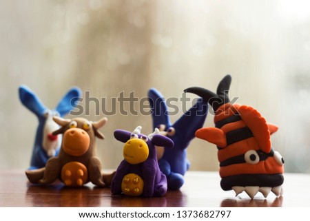 Animals (rabbits, cows and fish) from multi-colored plasticine, which hardens. Children's creativity. Funny clay toys.