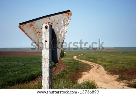 Weathered and crooked road sign in the countryside. Crimea, Ukraine.