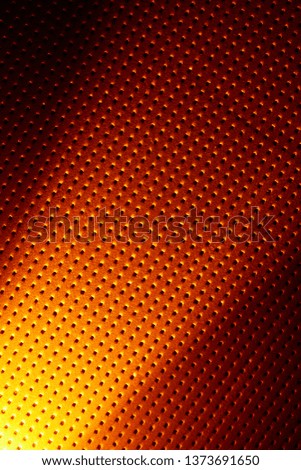 Diagonal bright scattered yellow light beam on an orange background to a black dot