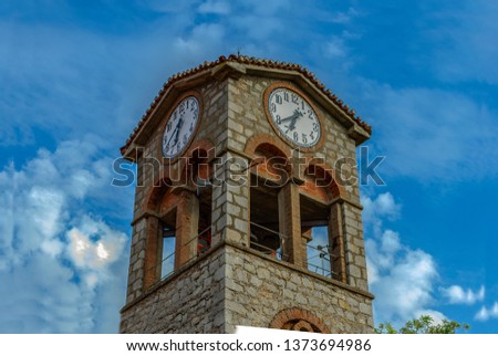 Close up of a stone bell tower with cloudy blue sky background at the traditional village Central Greece