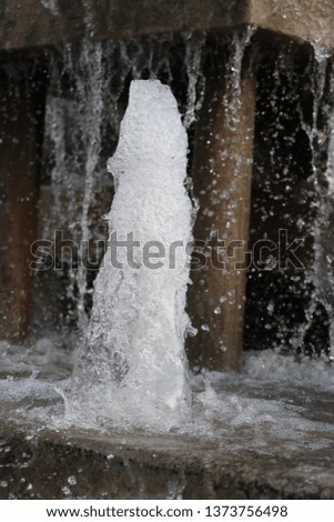 Freeze frame of water spashing out of a fountain.