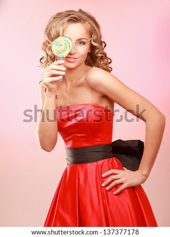 young happy woman with lollipop, isolated on pink background