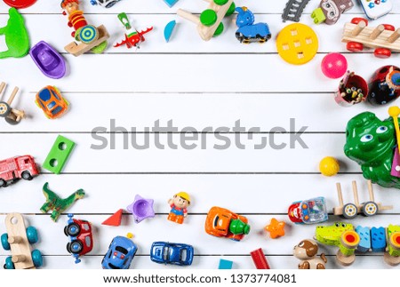 Top view of colorful toys on a wooden white background. Frame with toys and empty copy space.