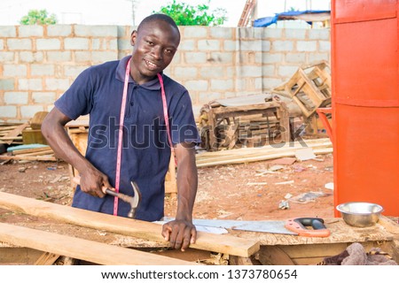 local african carpenter at work smiling Royalty-Free Stock Photo #1373780654
