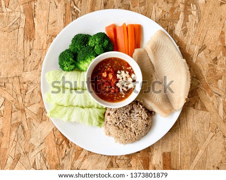 Steamed Tilapia fish with whole grain rice, steamed vegetables served with hot and sour sauce on the side.