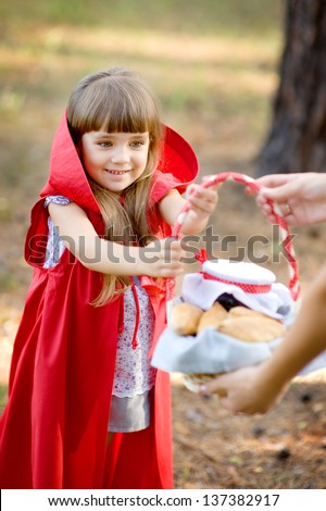 mother hands over to the daughter a basket with food. the fairy tale " Red Riding Hood"