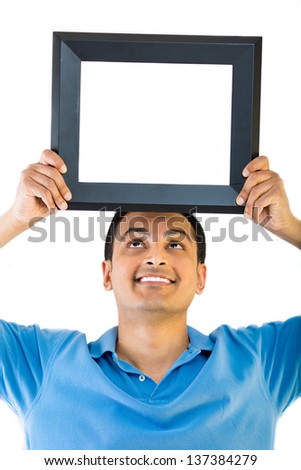 A good looking young man balancing an empty picture frame on his head - Copyspace