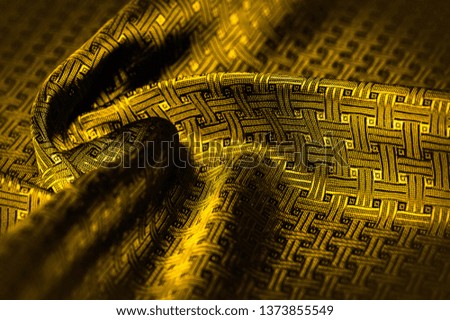 Background texture, pattern. Yellow, mustard silk fabric with a small checkered pattern. Muffled yellow braided with subtitles with sparkles - a bright chart-plot design. Individual pieces.