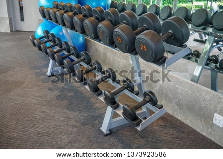 Dumbells set left on the racks in the gym. Healthy or sport concept.