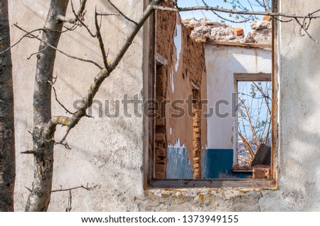 The ruins of an old earthen house without a roof. Holes in the wall at the site of windows and doors.