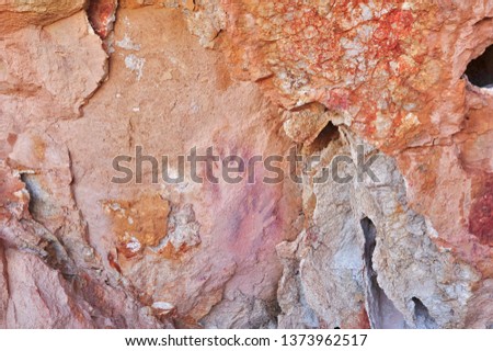 Two hand stencils in a rocky cave, painted by an unknown Aboriginal artist five thousand years ago.