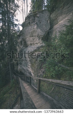 tourist trail with wooden pathwalk and stairs near sandstone cliffs. river gauja in Latvia. The cliff of Sietiniezis - vintage retro look