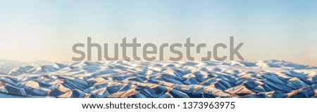 panoramic photo of amazing mountains landscape covered with snow at the sunrise
