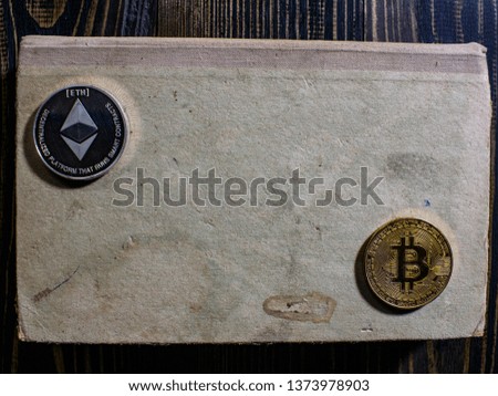 Bitcoin and Ethereum on an old book lying on a wooden table.New virtual money