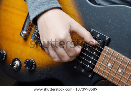 Playing the electrical guitar. Closeup view of playing electric guitar. Young man playing his electrical  guitar on white background