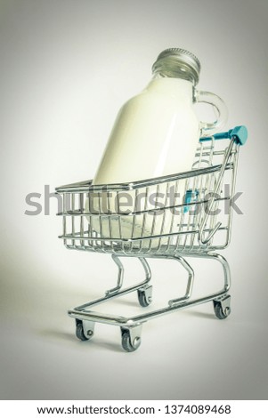 Glass bottle with milk in a shopping cart close-up. Photos in the old retro style.